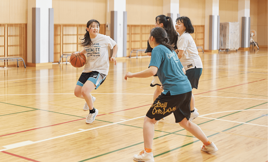 4人の女子生徒がバスケットをしている写真