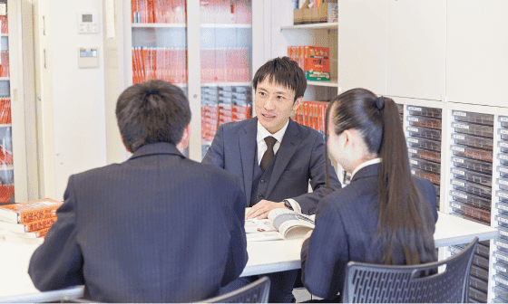 複数人の生徒と先生が会話をしている写真