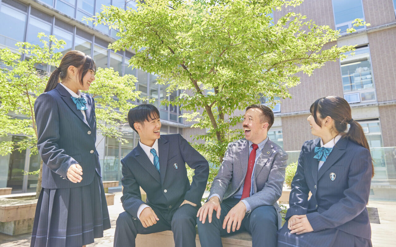 先生と生徒が持っているPC画面を見ている写真